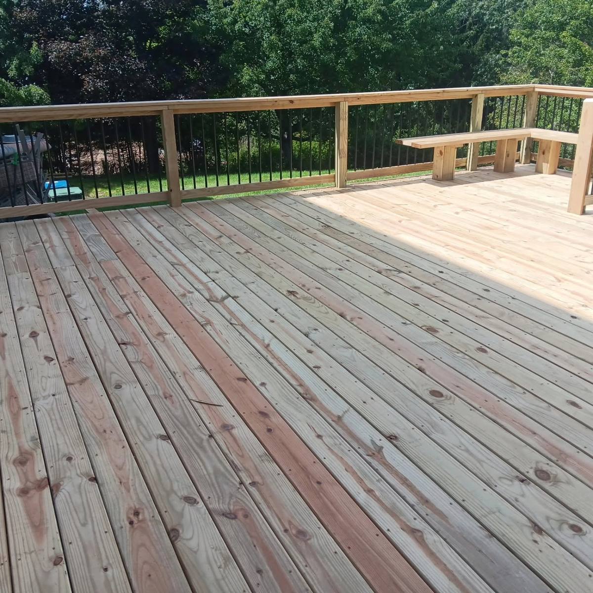 Wide view of a new wood deck with a built-in corner bench